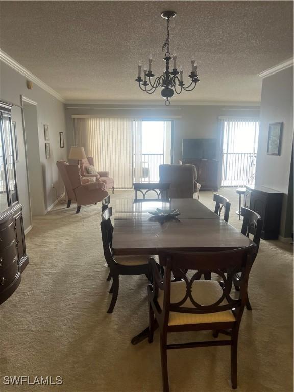 carpeted dining space with crown molding, a chandelier, and a textured ceiling