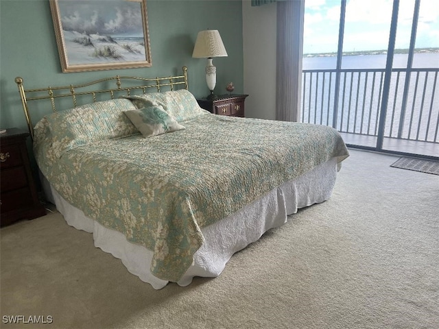 bedroom with access to exterior, carpet, and a water view