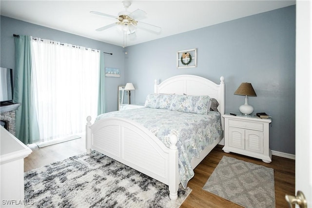 bedroom featuring multiple windows, hardwood / wood-style flooring, and ceiling fan