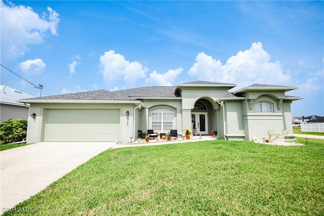 view of front facade with a garage, a front yard, and french doors