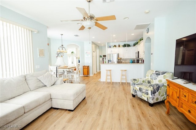 living room featuring ceiling fan and light wood-type flooring