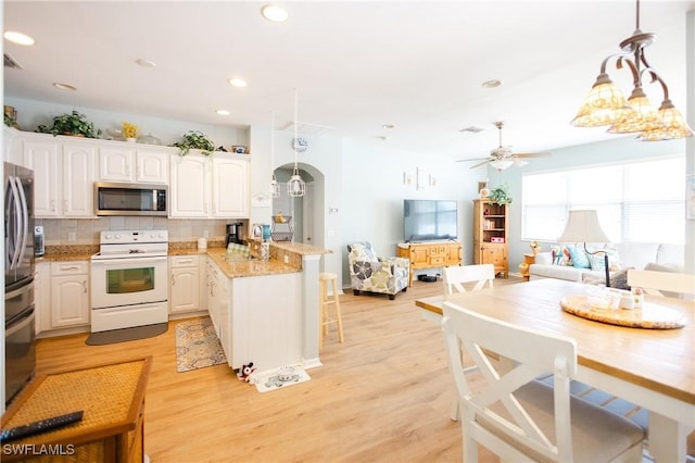 kitchen with stainless steel appliances, white cabinetry, pendant lighting, and kitchen peninsula