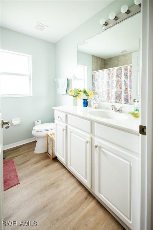 bathroom featuring vanity, toilet, curtained shower, and hardwood / wood-style floors