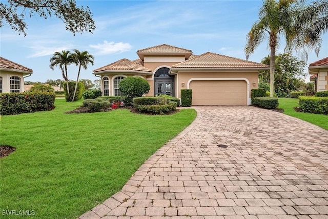 mediterranean / spanish home featuring a garage and a front yard