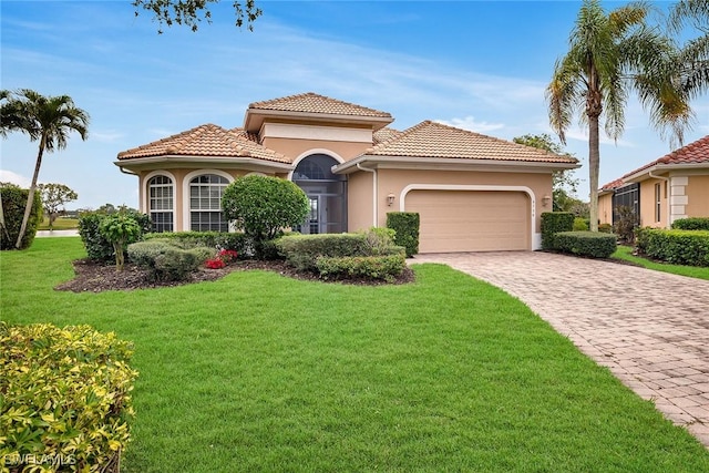 mediterranean / spanish house with a garage and a front yard