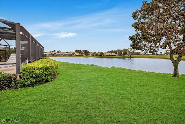 view of yard with a water view and glass enclosure