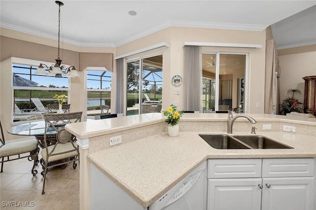 kitchen featuring sink, light tile patterned floors, dishwasher, white cabinetry, and decorative light fixtures