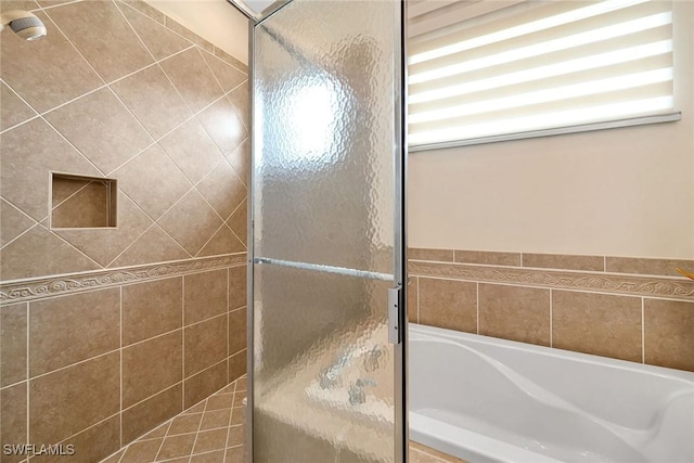 bathroom featuring shower with separate bathtub