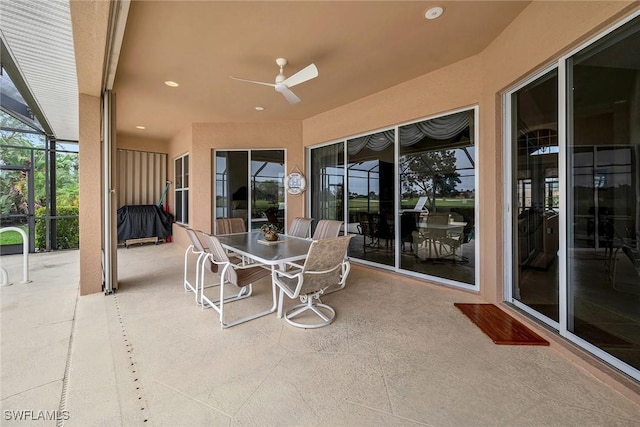 view of patio featuring ceiling fan and glass enclosure