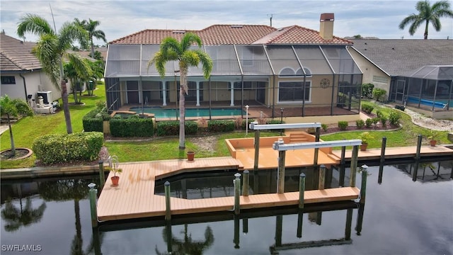 view of dock with a yard, a lanai, and a water view