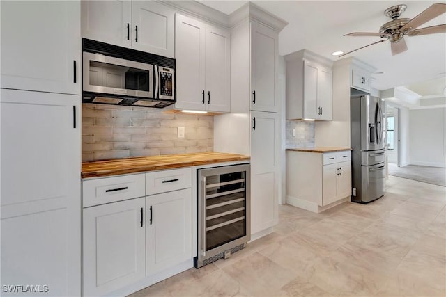 kitchen featuring backsplash, white cabinets, wooden counters, beverage cooler, and stainless steel appliances