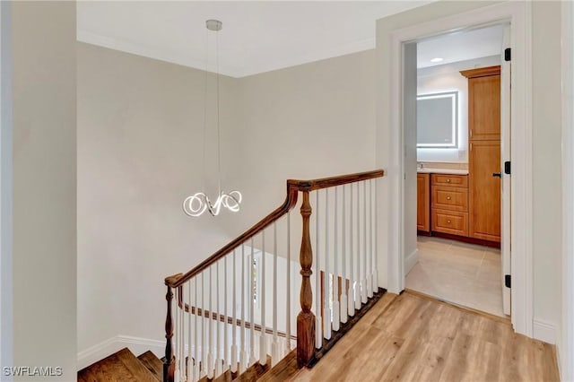 staircase featuring wood-type flooring and an inviting chandelier