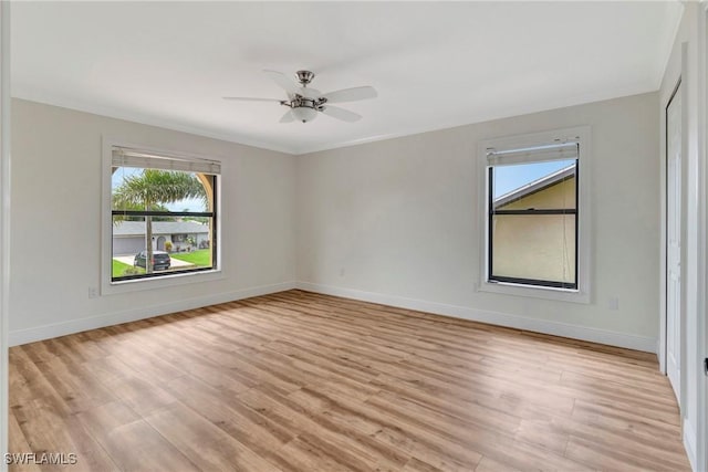 empty room with crown molding, ceiling fan, and light wood-type flooring