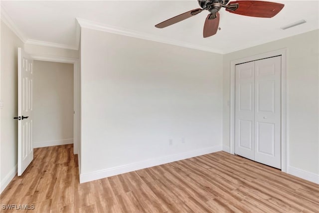 unfurnished bedroom with ornamental molding, a closet, ceiling fan, and light hardwood / wood-style flooring