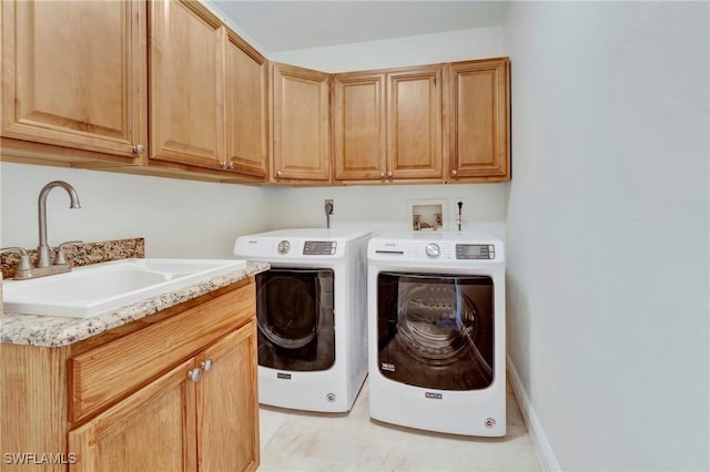 laundry room with sink, washer and clothes dryer, and cabinets