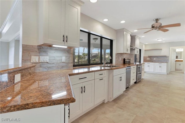 kitchen featuring sink, white cabinetry, appliances with stainless steel finishes, ceiling fan, and decorative backsplash