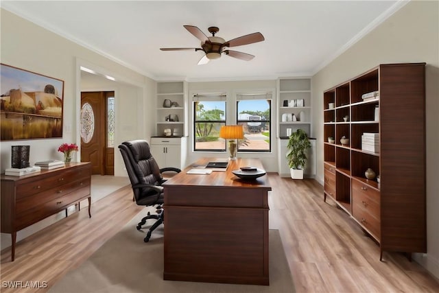 office space with built in shelves, ceiling fan, ornamental molding, and light hardwood / wood-style flooring