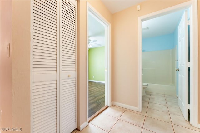 hall with light tile patterned flooring and baseboards