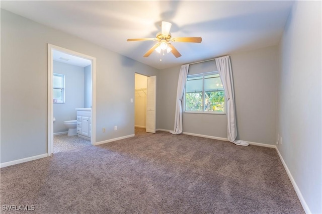 unfurnished bedroom with carpet, ceiling fan, ensuite bath, and baseboards