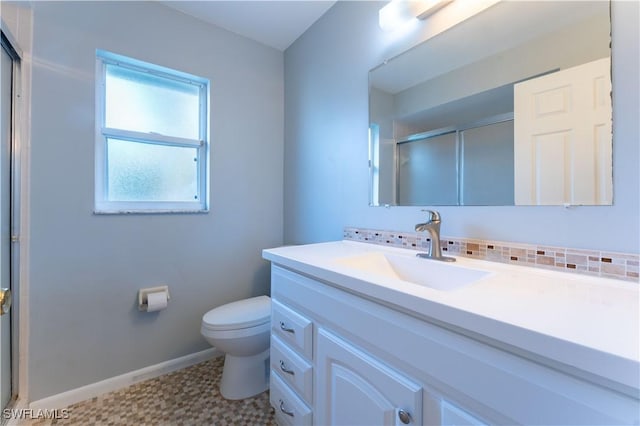 bathroom featuring toilet, vanity, baseboards, a shower stall, and decorative backsplash