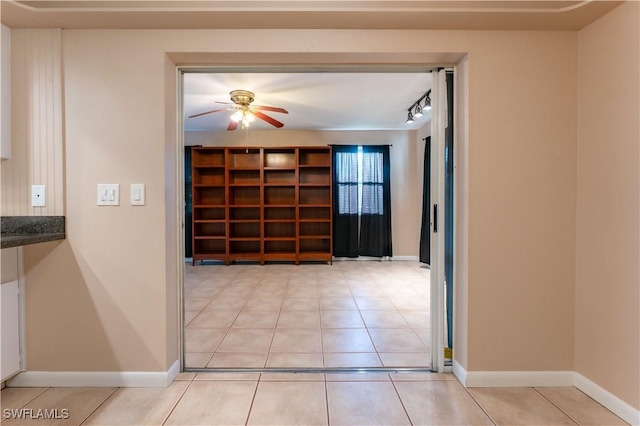 corridor with baseboards and light tile patterned flooring