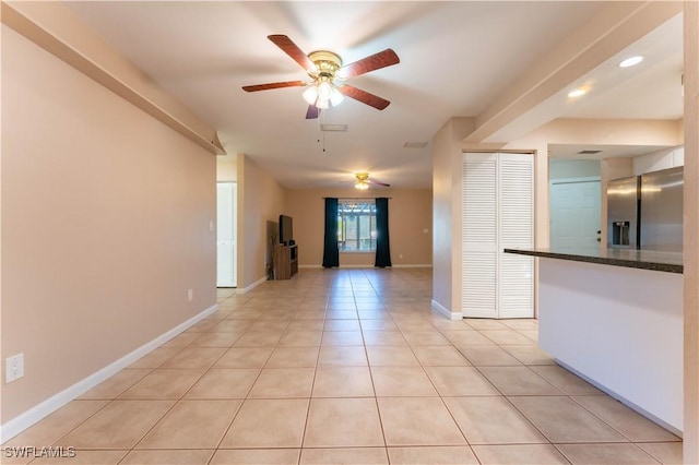 unfurnished room with light tile patterned floors, ceiling fan, visible vents, and baseboards