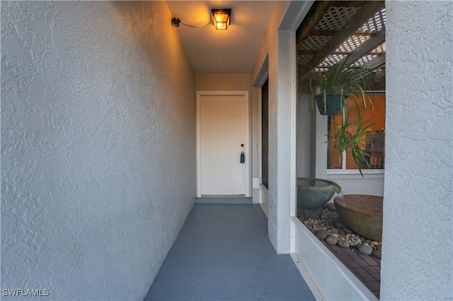 property entrance featuring a balcony and stucco siding