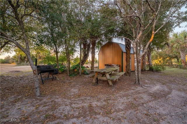 yard at dusk featuring an outbuilding and a detached garage