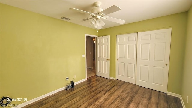 unfurnished bedroom with dark wood finished floors, a closet, visible vents, a ceiling fan, and baseboards