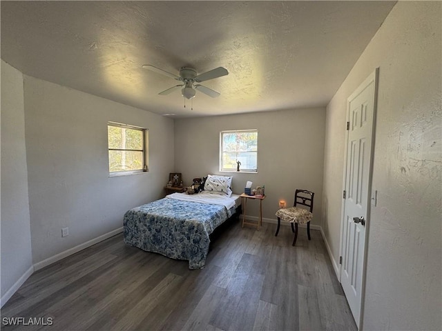 bedroom featuring hardwood / wood-style flooring, ceiling fan, multiple windows, and a textured ceiling