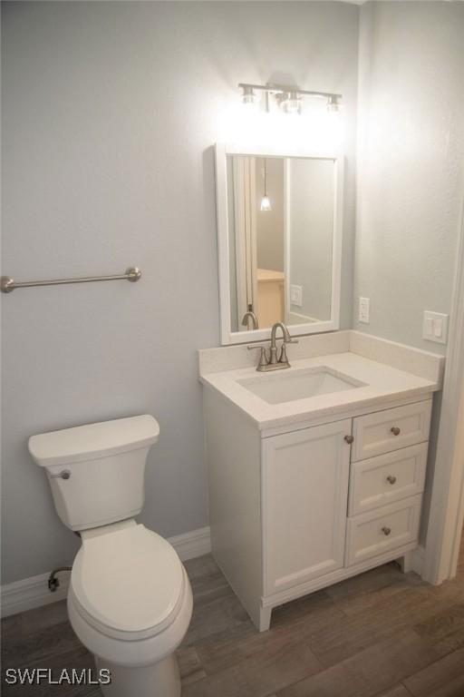 17291 Timber Oak Ln, Fort Myers, FL 33908 - bathroom with vanity, hardwood / wood-style flooring, and toilet