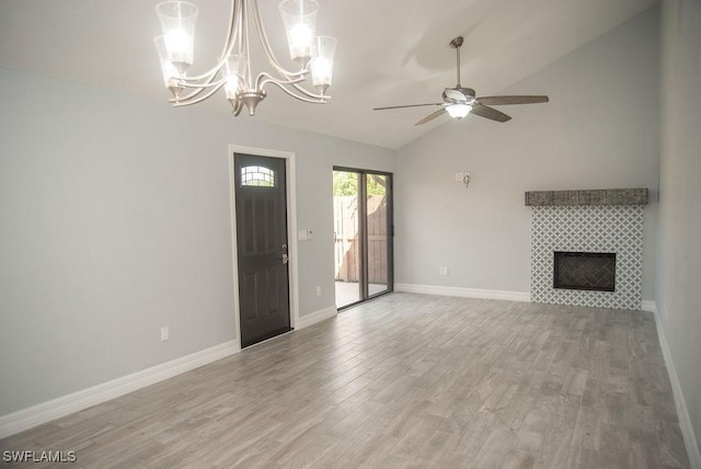 17291 Timber Oak Ln, Fort Myers, FL 33908 - unfurnished living room with ceiling fan, lofted ceiling, a tiled fireplace, and light wood-type flooring