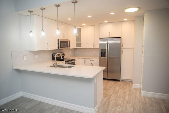 17291 Timber Oak Ln, Fort Myers, FL 33908 - kitchen with white cabinetry, appliances with stainless steel finishes, kitchen peninsula, and sink