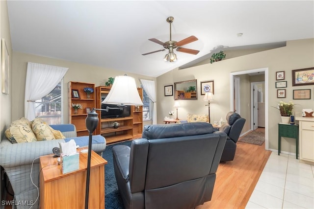 living room featuring light hardwood / wood-style flooring, vaulted ceiling, and ceiling fan