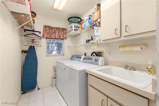 clothes washing area with cabinets, washing machine and dryer, sink, and light tile patterned floors