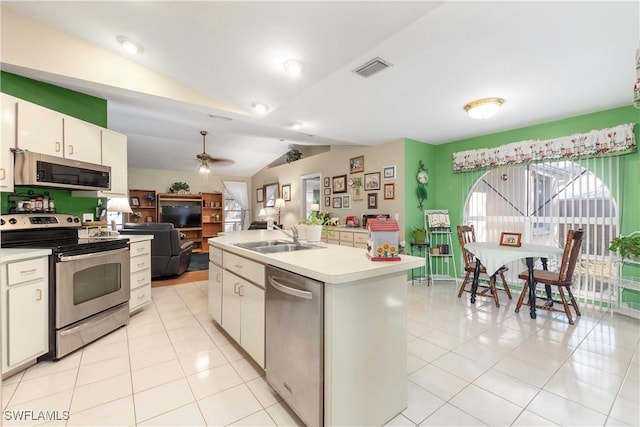 kitchen featuring stainless steel appliances, a kitchen island with sink, sink, and white cabinets