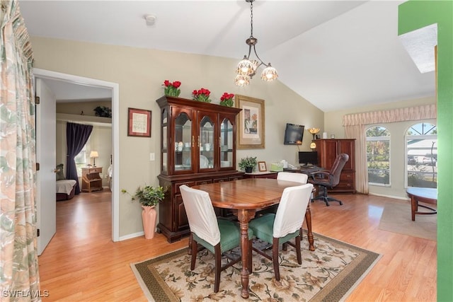 dining room featuring light hardwood / wood-style flooring, a notable chandelier, and vaulted ceiling