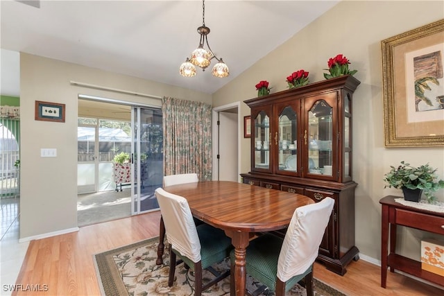 dining area featuring lofted ceiling, a chandelier, and light hardwood / wood-style flooring