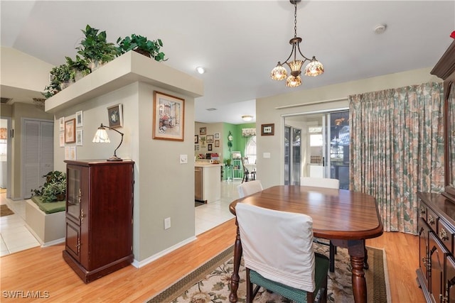 dining area featuring an inviting chandelier, light hardwood / wood-style flooring, and lofted ceiling