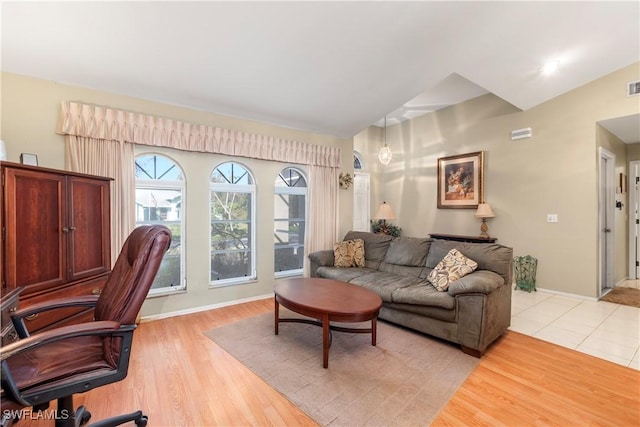 living room with vaulted ceiling and light wood-type flooring