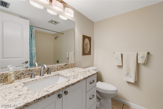 bathroom with vanity, tile patterned flooring, and toilet