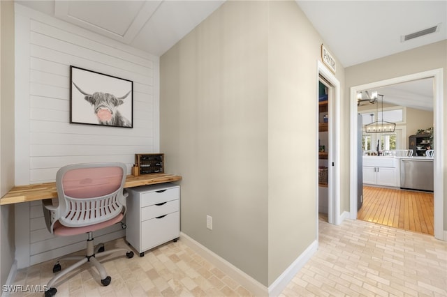 office with lofted ceiling and an inviting chandelier