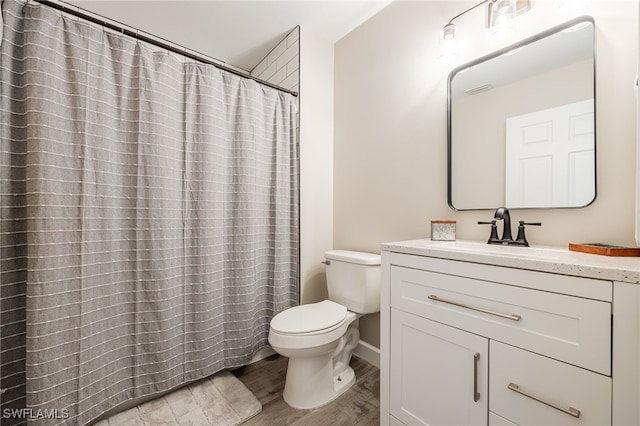 bathroom with hardwood / wood-style flooring, vanity, a shower with shower curtain, and toilet