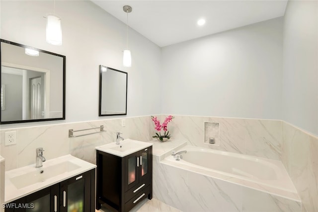 bathroom featuring vanity and tiled bath