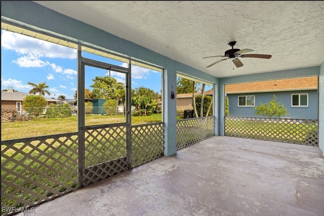 unfurnished sunroom featuring ceiling fan