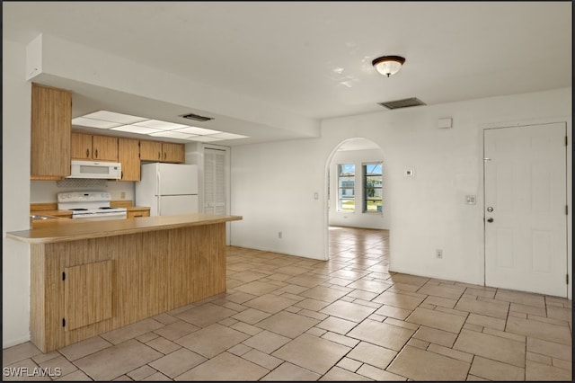 kitchen featuring white appliances and kitchen peninsula