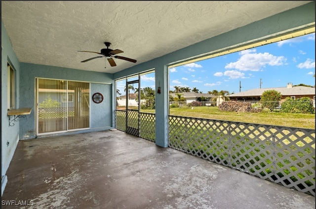 unfurnished sunroom with ceiling fan