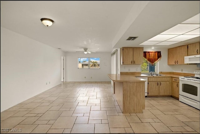 kitchen with ceiling fan, white appliances, kitchen peninsula, and sink