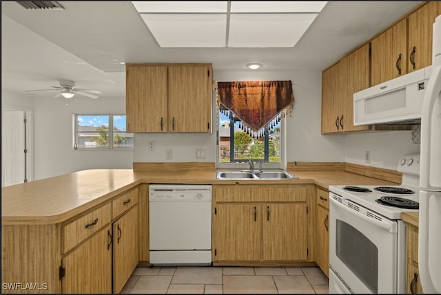 kitchen with plenty of natural light, sink, white appliances, and kitchen peninsula