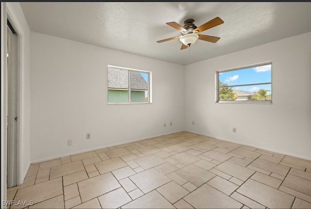 empty room with ceiling fan and a healthy amount of sunlight